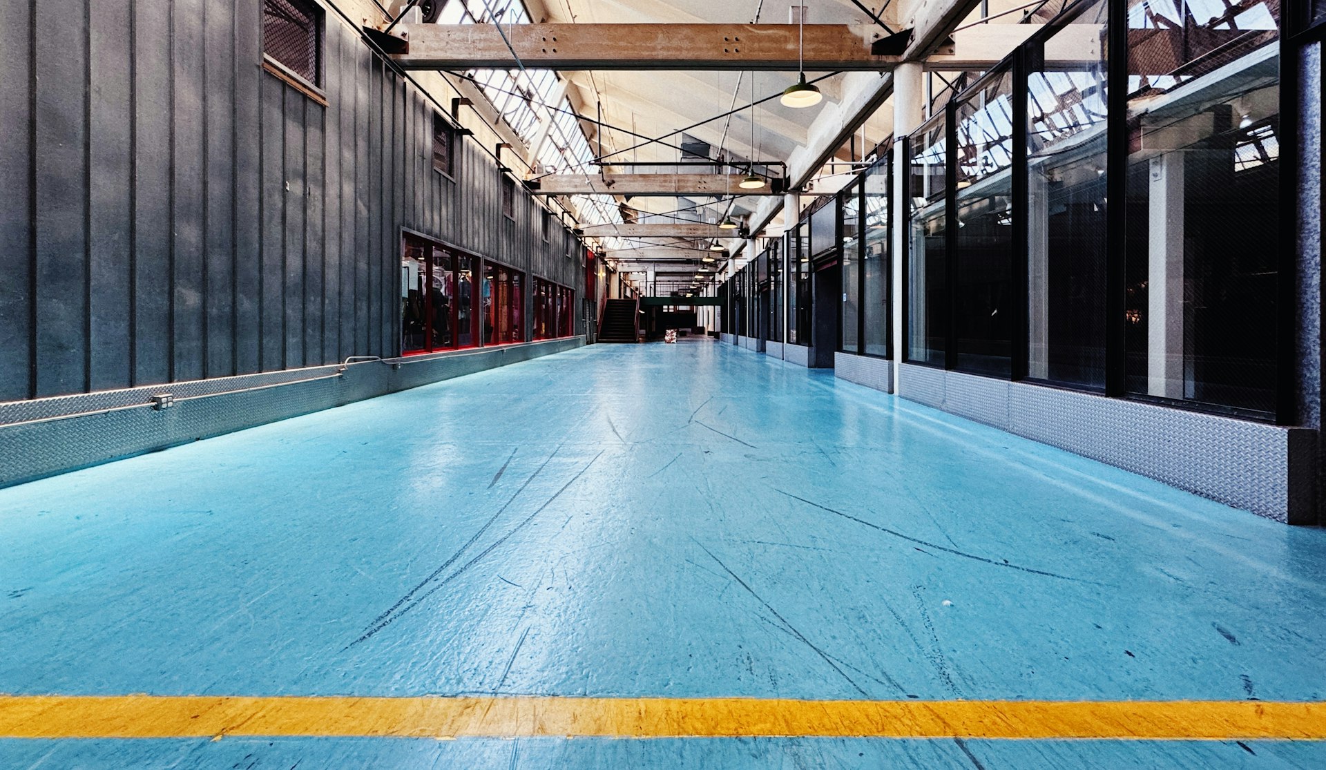 A large room with a blue floor and a yellow line